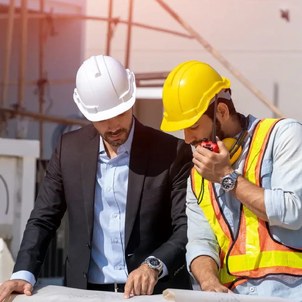 Licensed UAE contractors discussing a commercial building blueprint